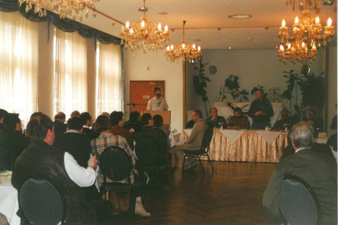 Die Vertreter*innen der Kreisverbände sitzen in einem festlichen Raum dem Rednerpult und der Tafel mit dem NABU-Vorstand zugewandt.